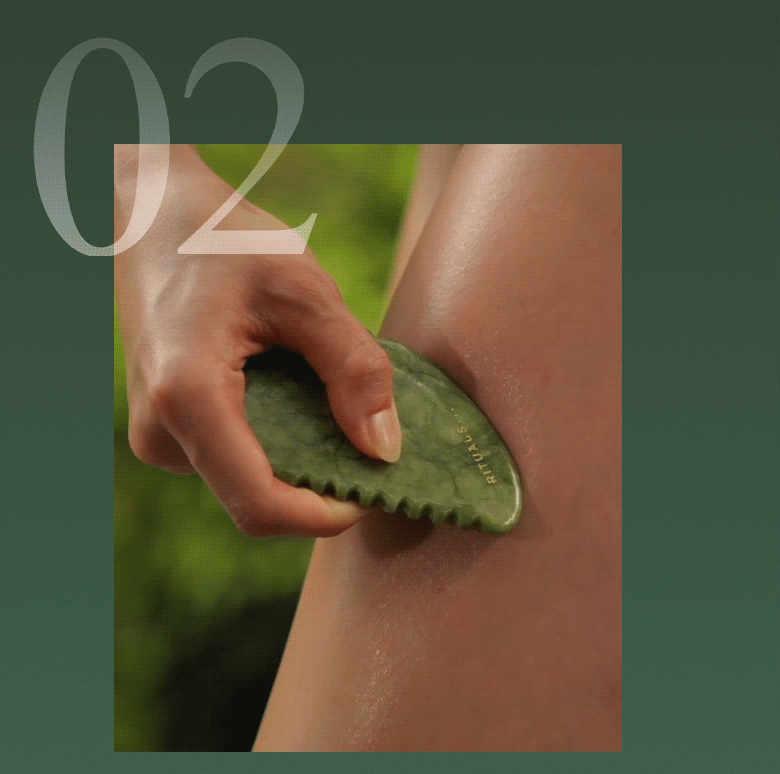Hand holding a green jade gua sha tool against skin