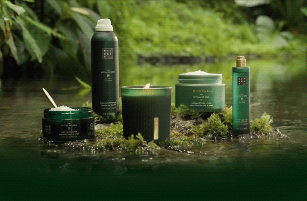 Complete Ritual of Jing collection featuring bottles, jars, and containers arranged on moss with natural greenery.