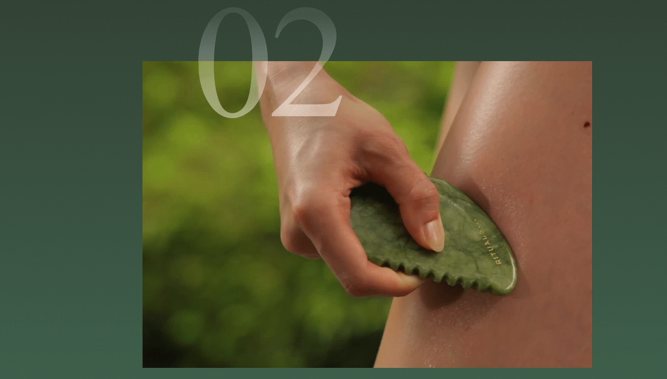 Hand holding a green jade gua sha tool against skin